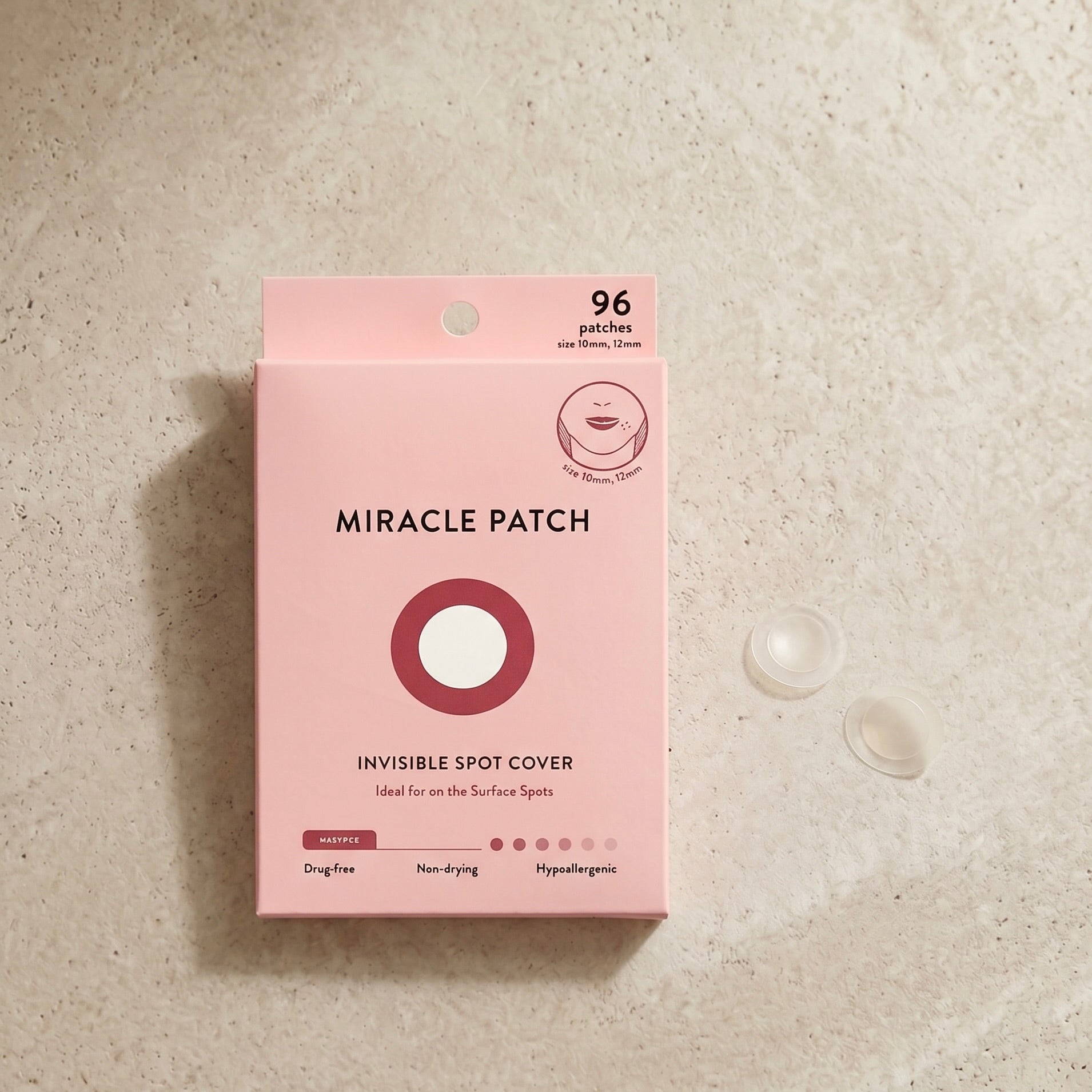 Pink packaging of Miracle Patch on a beige surface